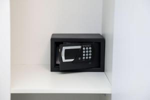 a black microwave sitting on a white shelf at Dello Iacono suite in Naples