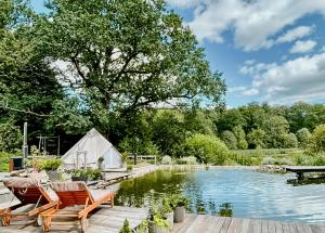 a couple of chairs sitting next to a pond at Pearl Of The Prairie in Tollered