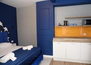 a bedroom with blue walls and a bed with towels at Dello Iacono suite in Naples