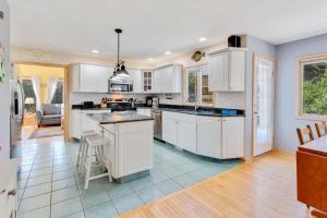 a kitchen with white cabinets and a kitchen island at 2160 - Mighty Duck in Duck