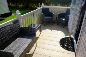 a patio with two chairs and a table on a deck at 64 Southfield - Skipsea Sands in Ulrome