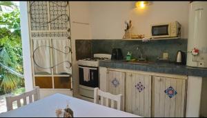 a kitchen with a stove and a table and a microwave at Abbá Departamentos in Mina Clavero