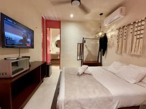 - une chambre avec un lit et une télévision murale dans l'établissement Hotel-Style Stay with Pool, à Mérida