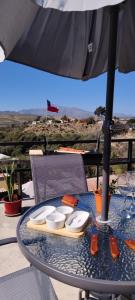 a table with an umbrella and a plate on it at Casa Turismo Freirina in Freirina