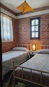 Un dormitorio con dos camas y una ventana. en Abbá Departamentos, en Mina Clavero