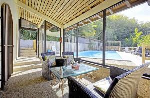 a patio with a table and chairs and a pool at Bastide piscine, pétanque, salle de jeux et spa in Guiche +4 photos