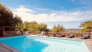a swimming pool with chaise lounge chairs at Bastide piscine, pétanque, salle de jeux et spa in Guiche