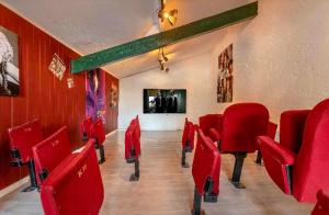 a conference room with red chairs and a wall at Bastide piscine, pétanque, salle de jeux et spa in Guiche