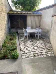 a patio with a table and chairs in a backyard at Chambres centre ville Chateauneuf in Châteauneuf-sur-Charente