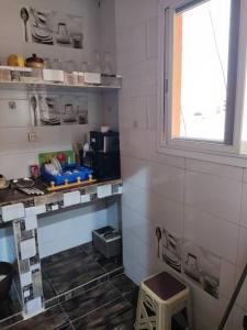 a kitchen with a window and a stool in a room at Grand Studio avec toutes les commodités in Dakar