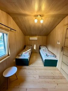 a room with two beds and a table in it at SuliCamp Kompleks Wypoczynkowy in Sulistrowice