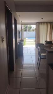 a hallway leading to a living room with a table and chairs at Casa de praia-Barra de são Miguel in Barra de São Miguel +13 photos