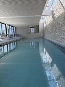 a large swimming pool in a building with water at Triagoz bord de mer Studio Trebeurden in Bonne Nouvelle