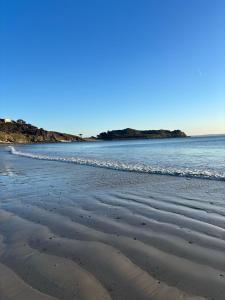 a beach with waves coming in from the ocean at Triagoz bord de mer Studio Trebeurden in Bonne Nouvelle +2 photos