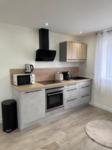 a kitchen with a stove and a microwave at Lonchamps 4 - New ground floor - Air conditioning Marlioz in Aix-les-Bains +7 photos