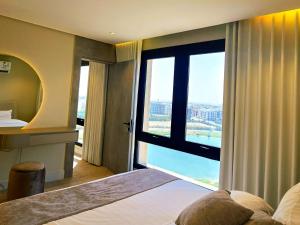 Un dormitorio con una gran ventana con vistas. en Luxury suite with sea view, en Al Khobar