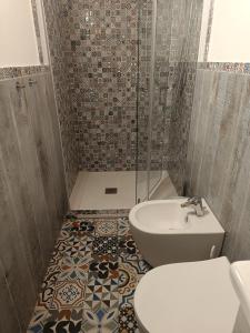 a bathroom with a shower and a toilet and a sink at La Dimora degli Scalzi Cabras in Càbras