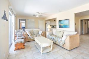 a living room with two couches and a table at Lobster Lodge in Duck Key