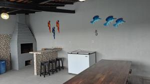 a kitchen with a refrigerator and a table and a fireplace at Ilha do Mosqueiro Família in Belém