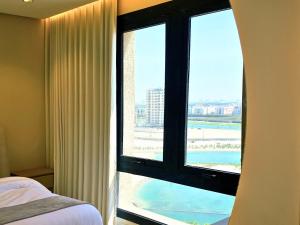 1 dormitorio con ventana y vistas a la playa en Luxury suite with sea view, en Al Khobar 7 fotos más