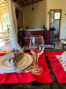 a table with a plate and a wine glass at Chalé por do sol in Santana do Riacho +33 photos