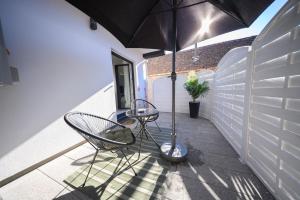 a patio with two chairs and an umbrella at Apartman Ena in Vinkovci +16 photos