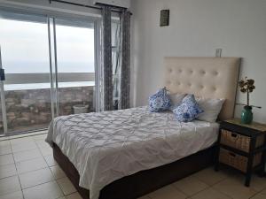 a bedroom with a bed with a view of the ocean at Stella Maris 135 in Amanzimtoti +24 photos