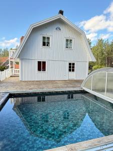 a house with a swimming pool in front of a building at DR ÅSA Apartment Penthouse w Pool by the Forest near a Golf course, Concerts and the Baltic Sea in Järna