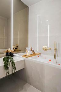 ein weißes Badezimmer mit Badewanne und Waschbecken in der Unterkunft Sia North Blue in Voluntari