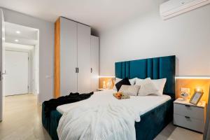 ein Schlafzimmer mit einem großen Bett mit blauem Kopfteil in der Unterkunft Sia North Blue in Voluntari