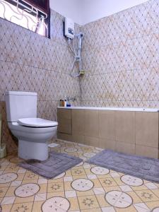 a bathroom with a toilet and a bath tub at Luxurious 3 bedroom bungalow in Kampala in Namugongo