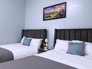 a bedroom with two beds and a picture on the wall at Luxurious 3 bedroom bungalow in Kampala in Namugongo