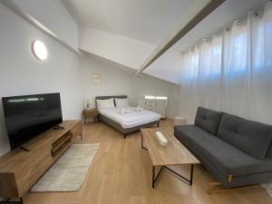 a living room with a couch and a television at Studio Yuka in Eilat