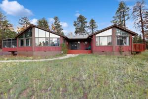 ein rotes Haus mit Glasfenstern auf einem Feld in der Unterkunft Lynx Cabin in Elden Pueblo