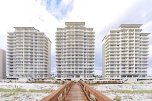 two tall white buildings with a bridge in front of them at Summerwind 0402 in Navarre