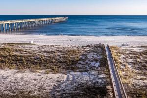 a pier on a beach next to the ocean at Summerwind 0402 in Navarre