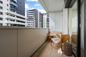 einen Balkon mit einem Stuhl und Blick auf die Gebäude in der Unterkunft Sia North Blue in Voluntari