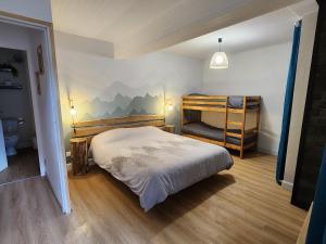 ein Schlafzimmer mit einem Bett und einem Etagenbett in der Unterkunft Maison au pied des montagnes ariégeoises in Quié