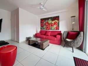 Saint MartinにあるMango Rouge, 2 bedrooms & poolの赤いソファと椅子のあるリビングルーム