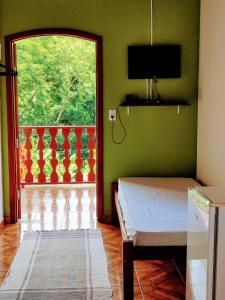 a bedroom with a bed and a large window at Pousada Canto Verde in Paraty