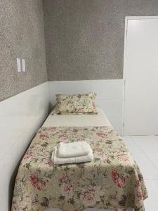 a small bedroom with a bed with a blanket at Cantinho da Barra in Barra dos Coqueiros
