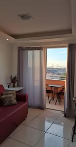 un soggiorno con divano e vista su un patio di Flat beira-mar em Natal a Natal