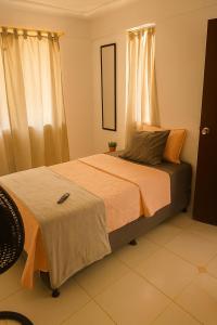a bedroom with a bed with orange sheets and a mirror at Ana home in Neiva