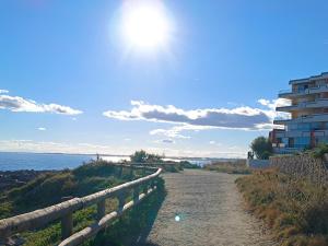 a dirt road next to the ocean with a building at Beautiful apartment with direct beach access in Sète