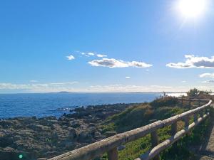 a view of the ocean from a wooden fence at Beautiful apartment with direct beach access in Sète +6 photos