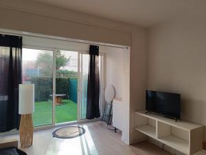 a living room with a television and a large window at Beautiful apartment with direct beach access in Sète