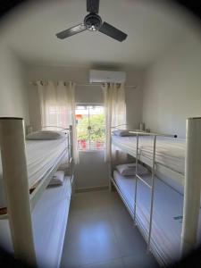 2 stapelbedden in een kamer met een plafondventilator bij Dormitório Barreto in Bom Jesus da Lapa
