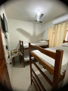 een kamer met drie stapelbedden en een tv bij Dormitório Barreto in Bom Jesus da Lapa +41 foto's