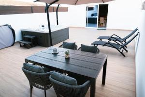 a table with chairs and an umbrella in a room at Doña Carmen 2 in Las Playitas