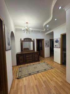 a living room with a chandelier and a wooden floor at spacious apartment in Almaty